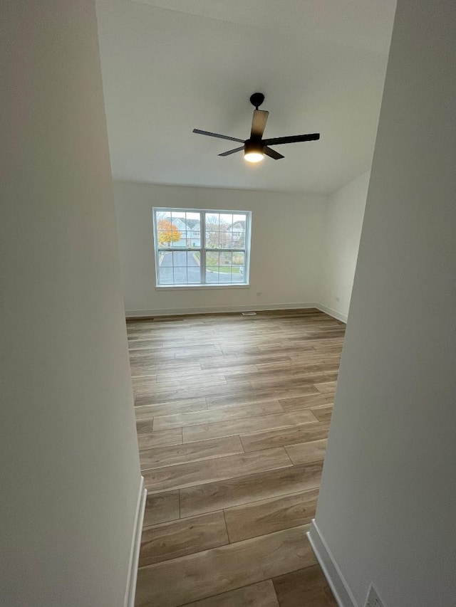 spare room with light hardwood / wood-style floors and ceiling fan