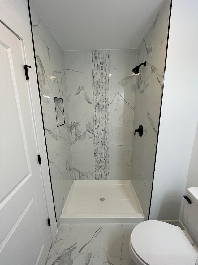 bathroom featuring toilet and tiled shower