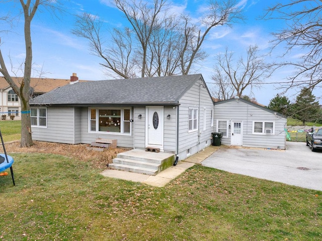 ranch-style home with a patio area, a trampoline, and a front lawn