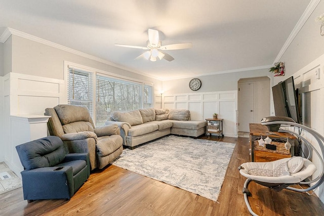 living room with ceiling fan, crown molding, and wood-type flooring