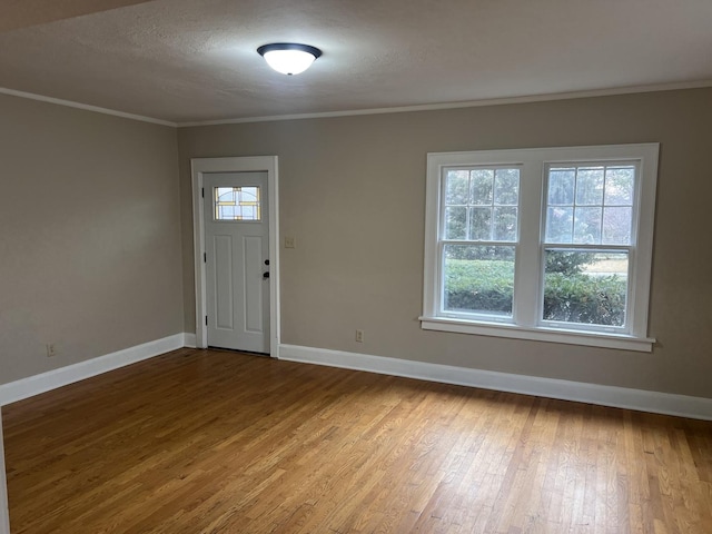 foyer with crown molding, hardwood / wood-style floors, and a textured ceiling