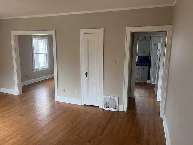 unfurnished bedroom featuring hardwood / wood-style flooring and ornamental molding