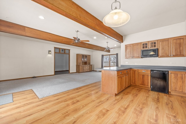 kitchen featuring decorative light fixtures, a peninsula, open floor plan, dark countertops, and glass insert cabinets