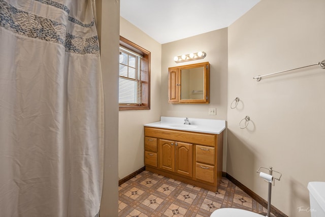 full bathroom with toilet, tile patterned floors, baseboards, and vanity