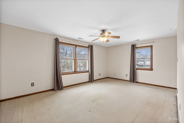 unfurnished room featuring light carpet, ceiling fan, visible vents, and baseboards