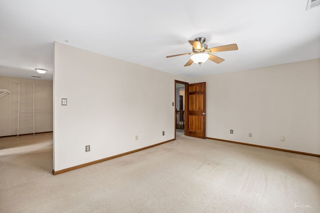 empty room featuring baseboards, ceiling fan, visible vents, and light colored carpet