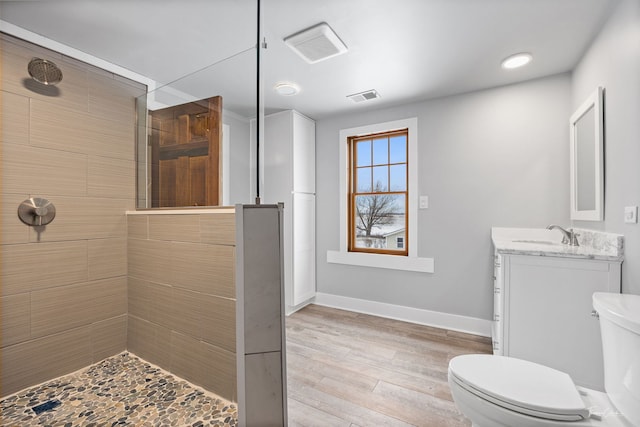 full bath featuring toilet, wood finished floors, vanity, visible vents, and baseboards