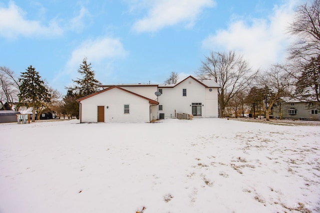 view of snow covered back of property