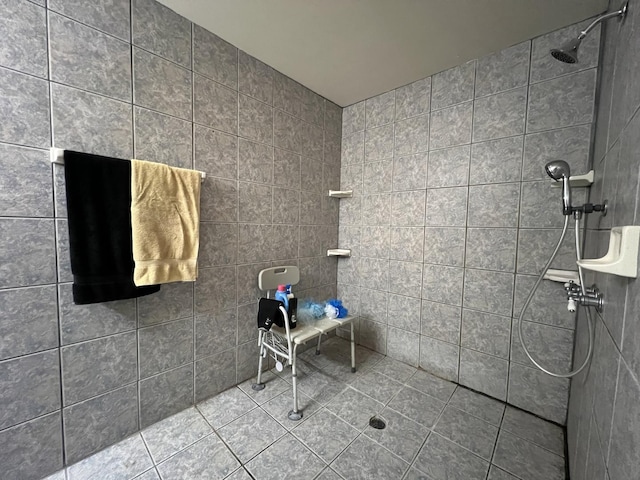 bathroom with a tile shower, tile patterned floors, and tile walls