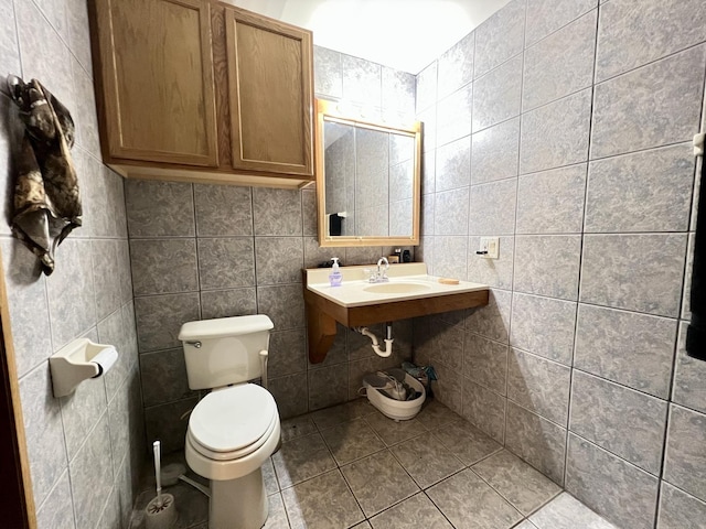 bathroom featuring tile patterned flooring, sink, toilet, and tile walls