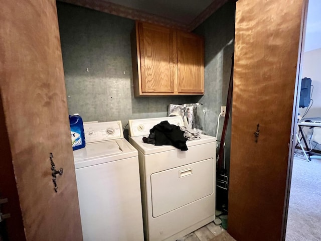 laundry area featuring washer and clothes dryer and cabinets