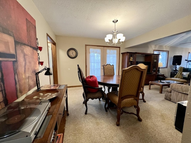 carpeted dining room featuring a chandelier, french doors, and a textured ceiling