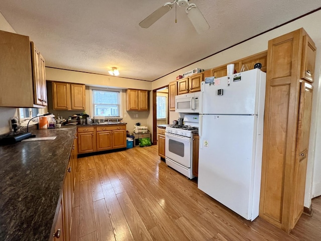 kitchen with a textured ceiling, white appliances, ceiling fan, sink, and light hardwood / wood-style floors