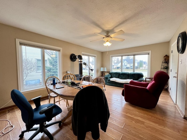 dining space featuring a wealth of natural light, ceiling fan, a textured ceiling, and light wood-type flooring