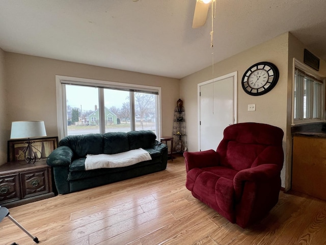 living room with light wood-type flooring and ceiling fan