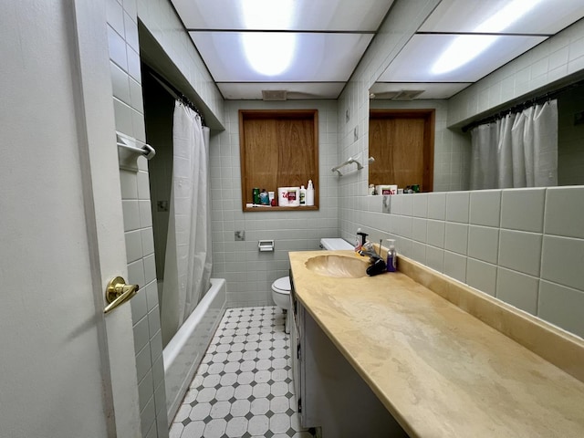 full bathroom with toilet, vanity, tile walls, and shower / bath combo