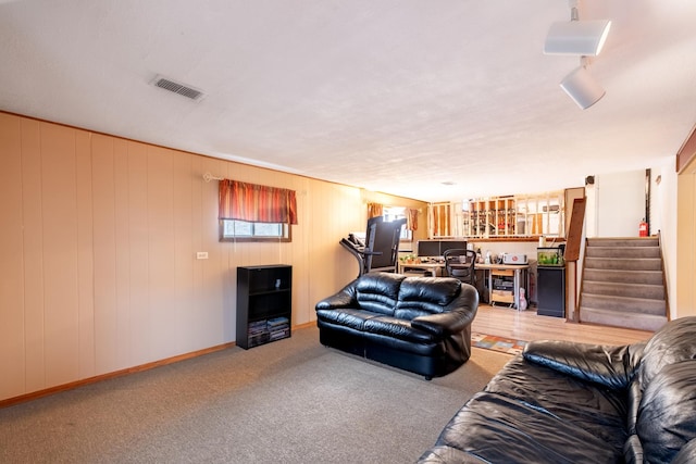 living room featuring wood walls and light colored carpet