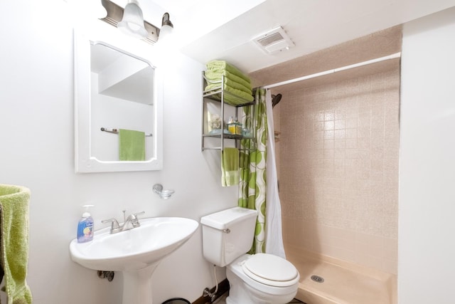 bathroom featuring a shower with curtain, sink, and toilet