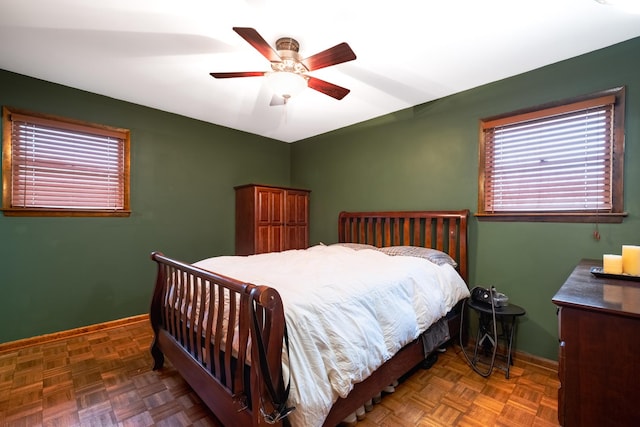 bedroom with dark parquet floors and ceiling fan