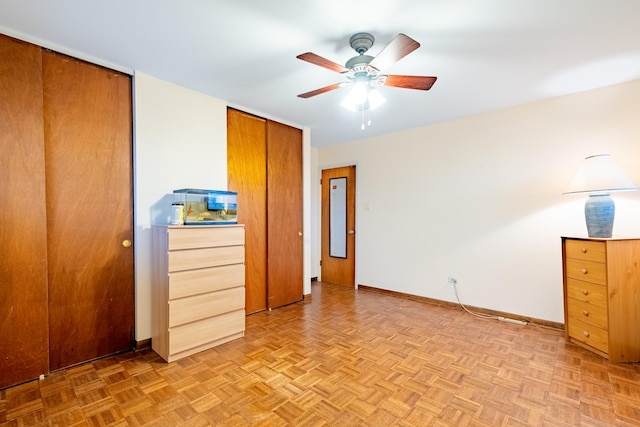 unfurnished bedroom with ceiling fan and light parquet floors