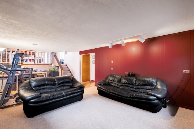 carpeted living room featuring a textured ceiling and track lighting