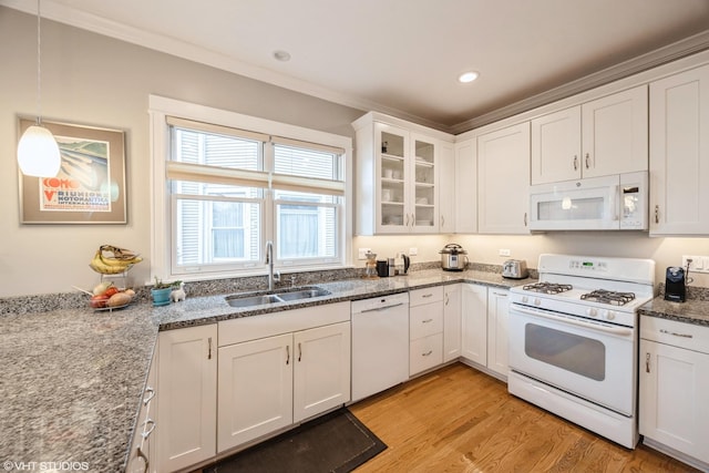 kitchen featuring white appliances, pendant lighting, light hardwood / wood-style floors, white cabinetry, and sink