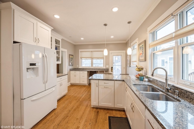 kitchen with sink, white appliances, white cabinetry, and hanging light fixtures