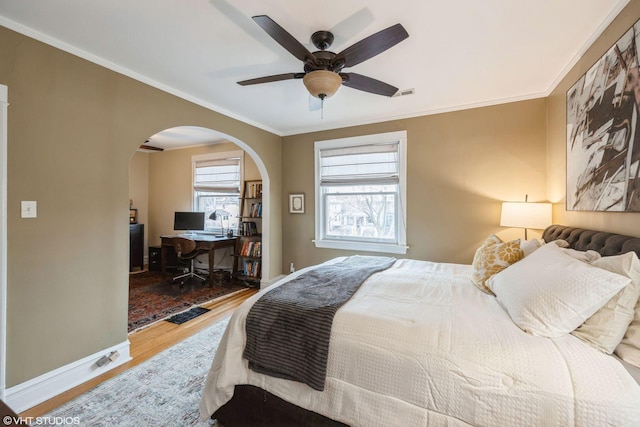 bedroom with ceiling fan, crown molding, and hardwood / wood-style floors