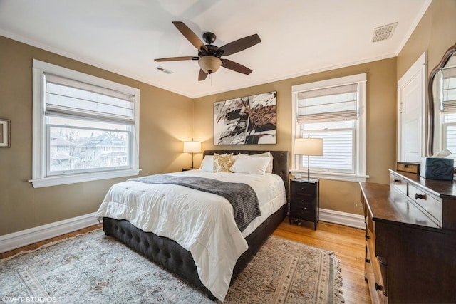 bedroom featuring ornamental molding, ceiling fan, light hardwood / wood-style flooring, and multiple windows