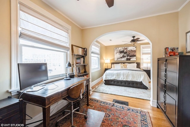 bedroom featuring ceiling fan, ornamental molding, and light hardwood / wood-style flooring