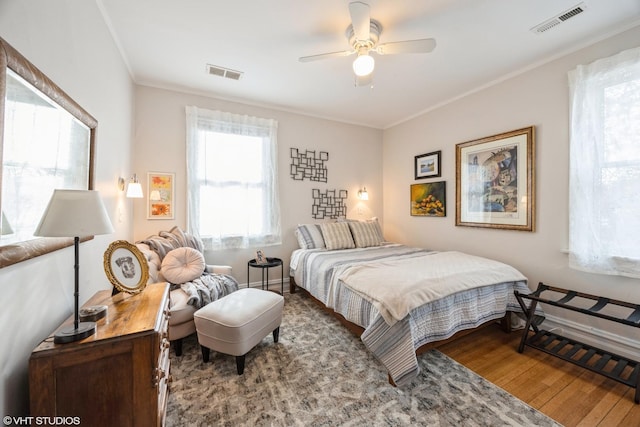 bedroom with ceiling fan, hardwood / wood-style flooring, and crown molding