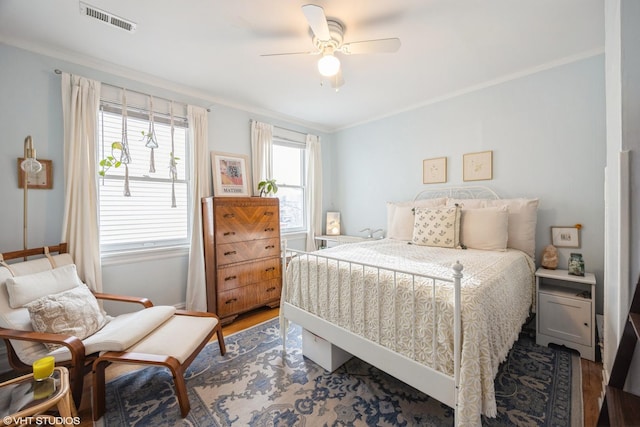 bedroom with ceiling fan, crown molding, and hardwood / wood-style flooring