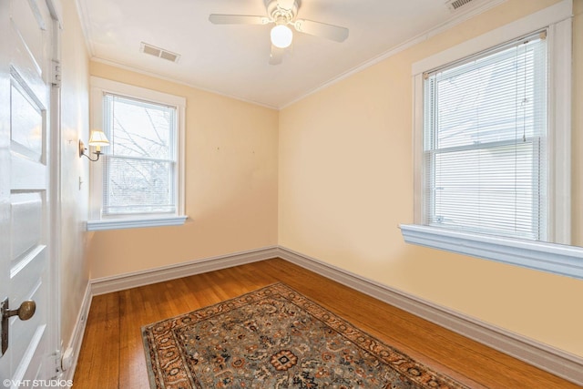 unfurnished room with ceiling fan, crown molding, and wood-type flooring