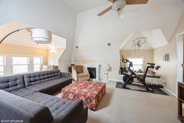 carpeted living room with ceiling fan and vaulted ceiling