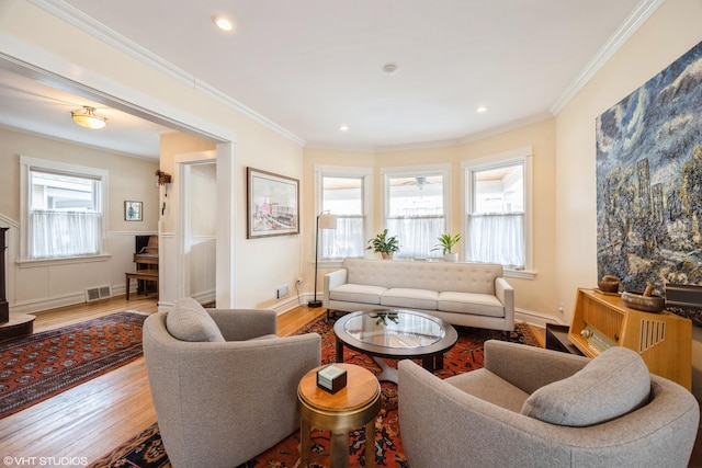 living room featuring wood-type flooring, ornamental molding, and ceiling fan