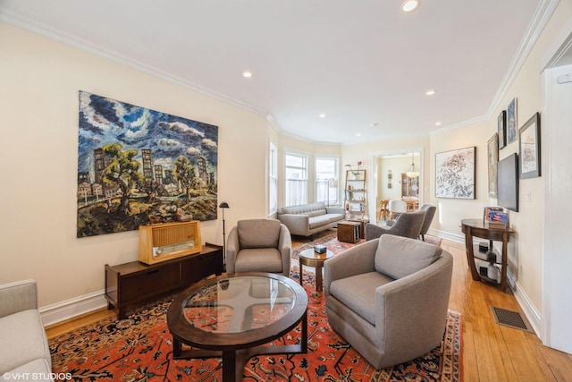 living room with light wood-type flooring and ornamental molding