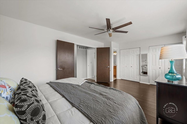 bedroom featuring two closets, hardwood / wood-style flooring, and ceiling fan