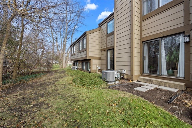 view of home's exterior featuring cooling unit and a lawn