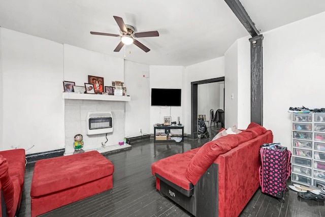 living room with a fireplace, dark hardwood / wood-style flooring, heating unit, and ceiling fan