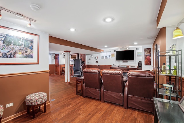 home theater with indoor bar, wood-type flooring, and track lighting