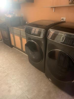 clothes washing area featuring separate washer and dryer and cabinets