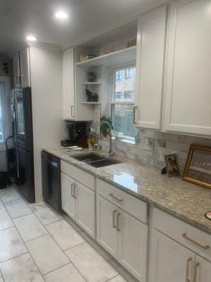 kitchen featuring white cabinetry, sink, tasteful backsplash, light stone counters, and black appliances