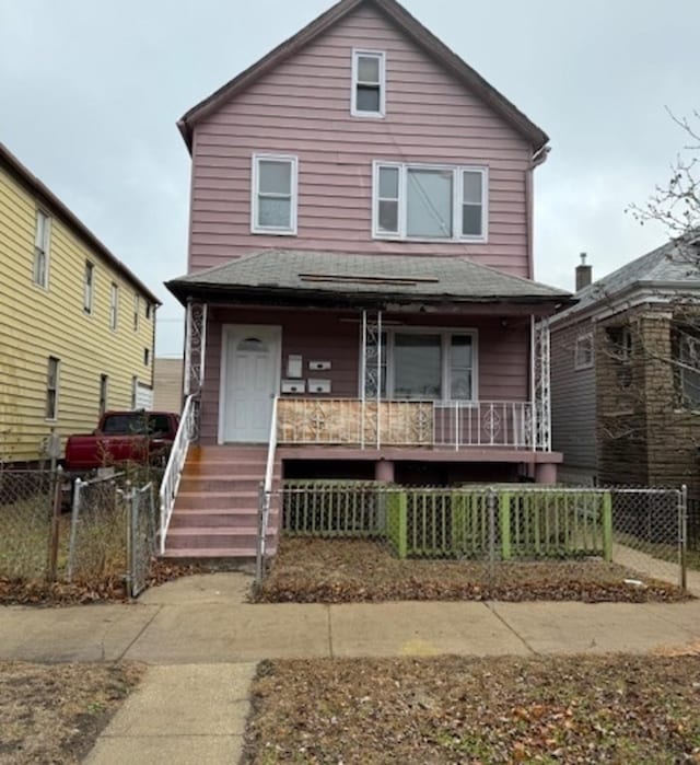 9903 S Exchange Ave, Chicago, IL 60617 - american foursquare style home featuring a porch, a fenced front yard, and a shingled roof