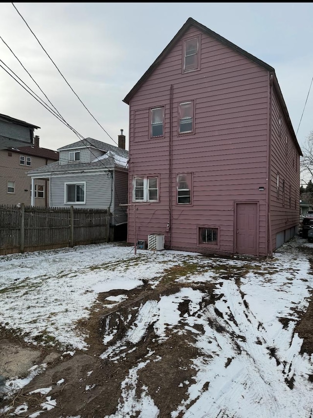 snow covered property with central AC