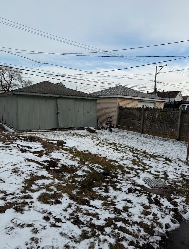 yard layered in snow featuring a storage shed