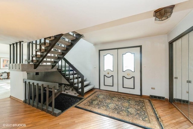 entrance foyer featuring french doors, hardwood / wood-style flooring, and plenty of natural light