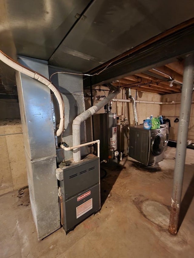 utility room with water heater, washing machine and dryer, and heating unit