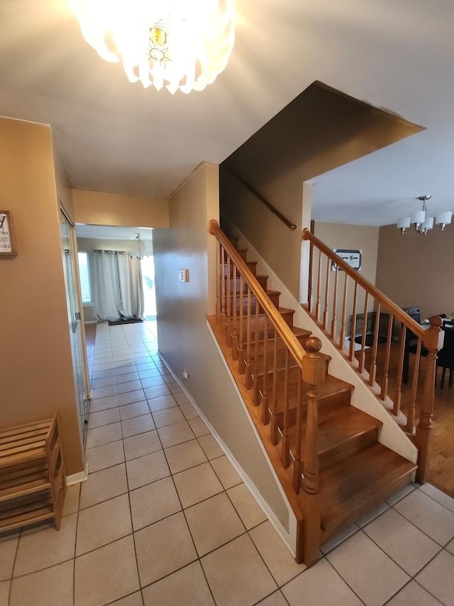 stairway featuring tile patterned floors and a notable chandelier