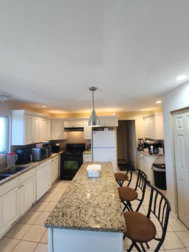 kitchen with a center island, hanging light fixtures, light tile patterned floors, white cabinets, and black appliances