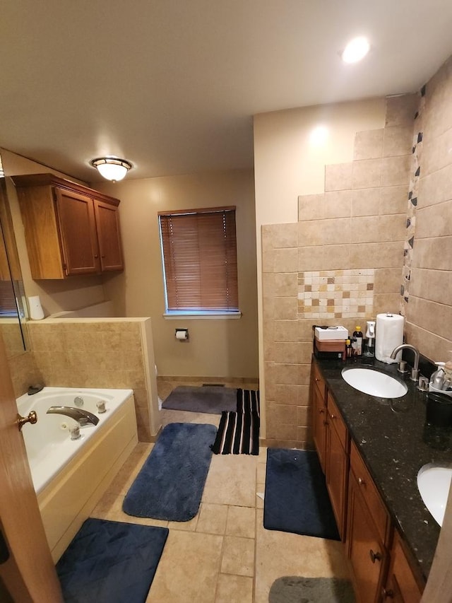 bathroom with tile patterned flooring, a bath, vanity, and tile walls